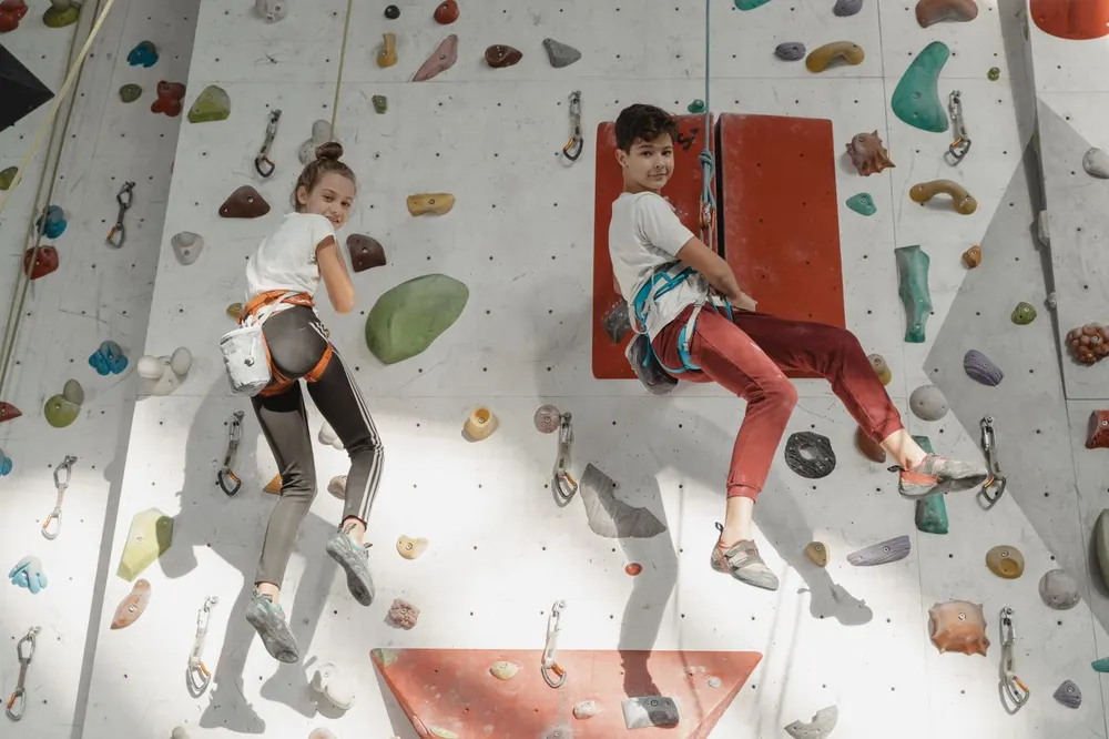 A climber reaching for a hold on an indoor climbing wall