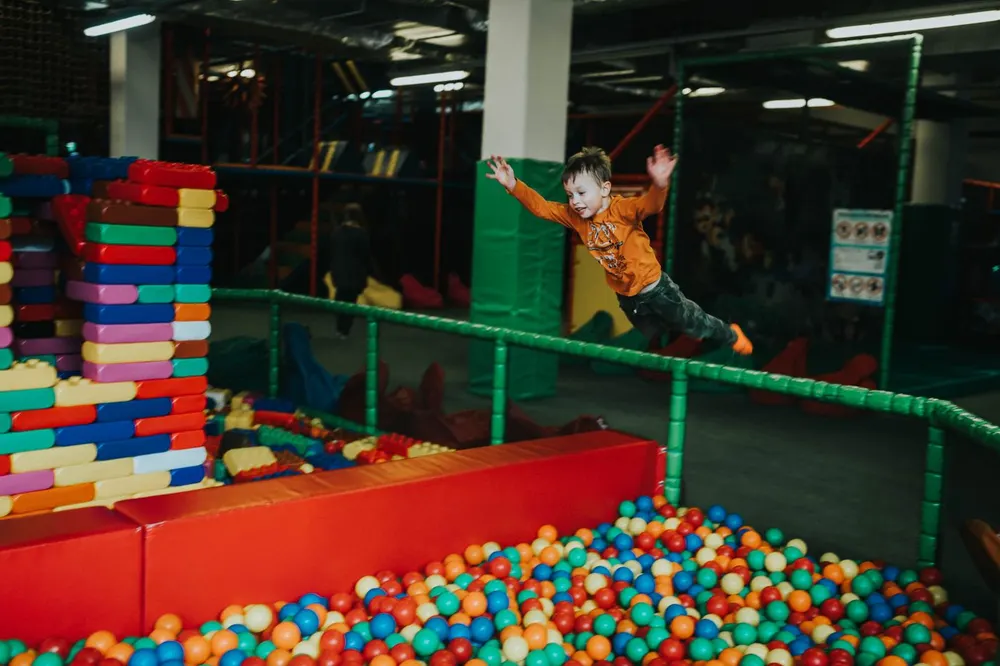 Children playing on a colourful indoor soft play frame